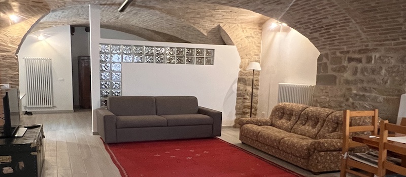 Un'affascinante zona giorno che unisce storia e comfort, tra pareti in pietra e antiche volte a botte.