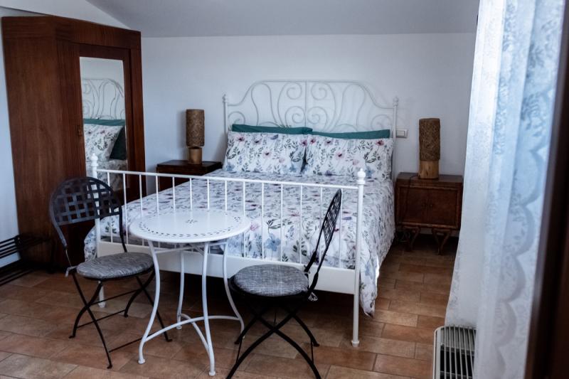Romantic atmosphere in the Peonia Room with a white wrought-iron bed and bistro seating. Romantic atmosphere in the Peonia Room with a white wrought-iron bed and bistro seating.