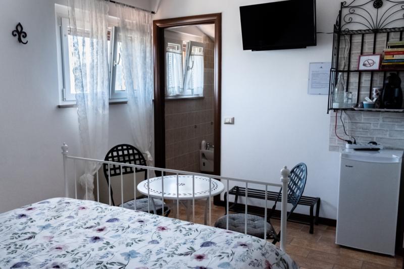 Romantic atmosphere in the Peonia Room with a white wrought-iron bed and bistro seating. Romantic atmosphere in the Peonia Room with a white wrought-iron bed and bistro seating.