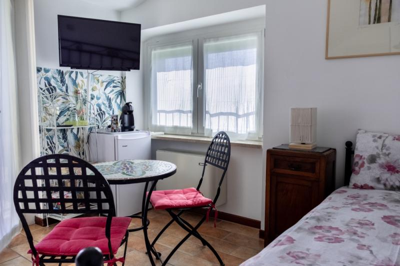 Detail of the cozy seating area in the Papavero (Poppy) Room at B&B C'era una volta, featuring a private table, TV, and minibar corner.
