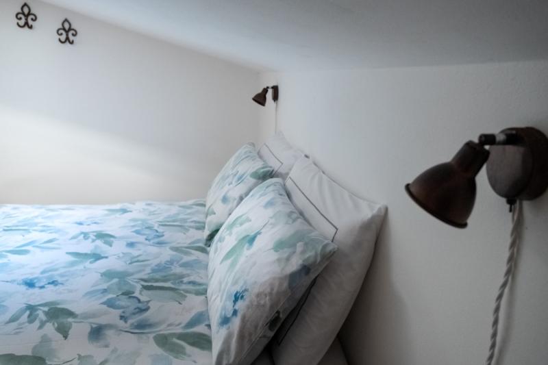 Elegant antique wooden wardrobe and cozy double bed in the attic Orchidea Room.