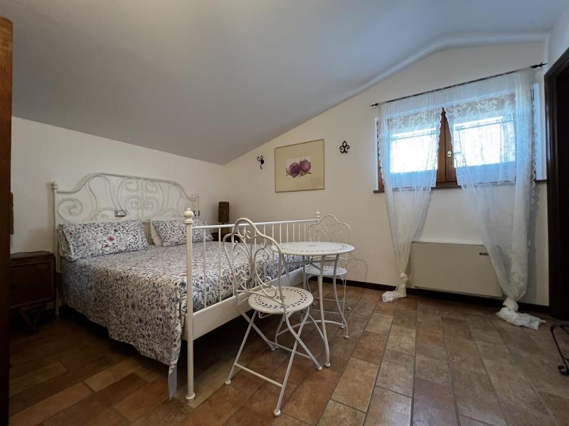 Romantic atmosphere in the Peonia Room with a white wrought-iron bed and bistro seating. Romantic atmosphere in the Peonia Room with a white wrought-iron bed and bistro seating.
