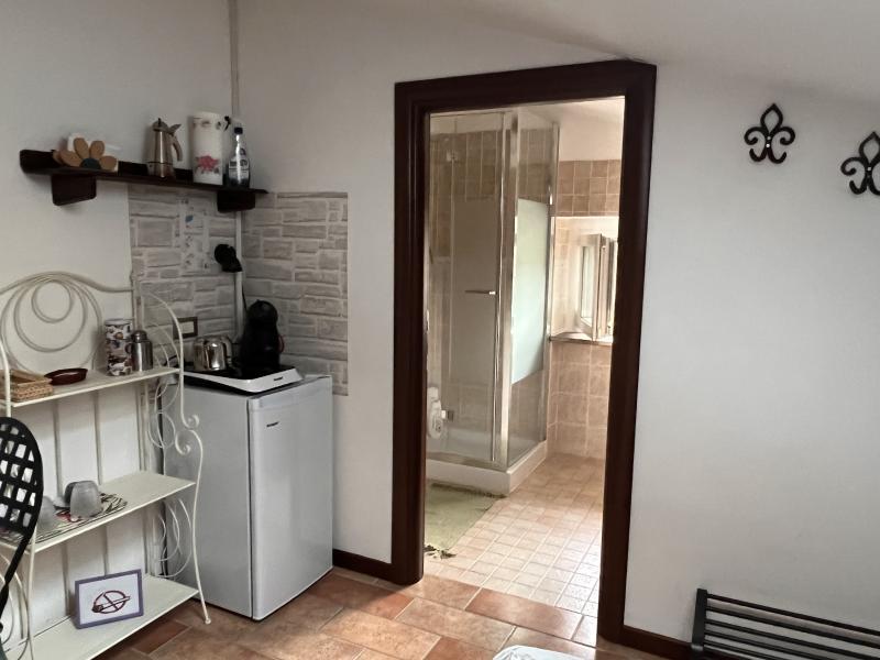 Interno della luminosa Camera Orchidea con area relax, minibar e vista sul bagno privato.