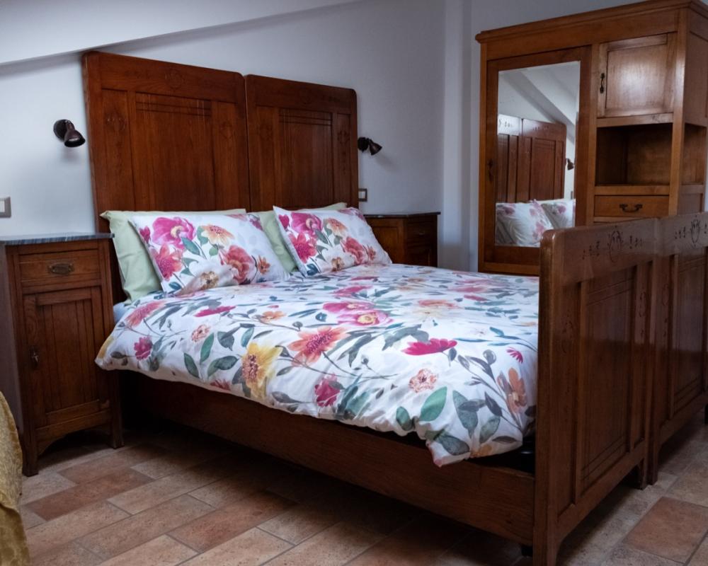 Letto matrimoniale e armadio in legno antico restaurato con specchio nella Camera Girasole del B&amp;B C'era una volta.